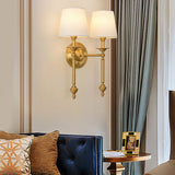 Single-head brass sconce lit in a living room