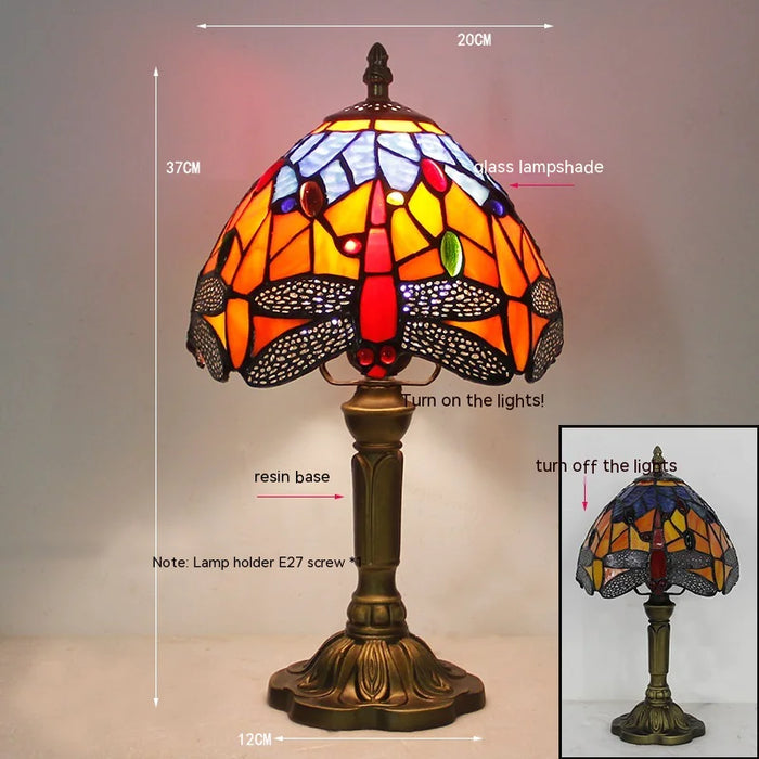 Stained glass dragonfly lamp lit in a dark room