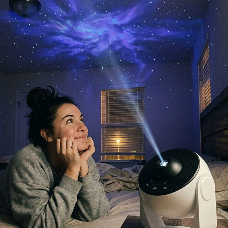 Young woman lying on her bed looking up at a starfield projected across her bedroom ceiling
